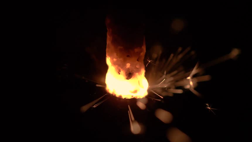 The metal burns and sparks fly off it