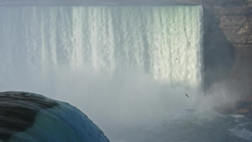 Waterfall plunges powerfully creating mist all around