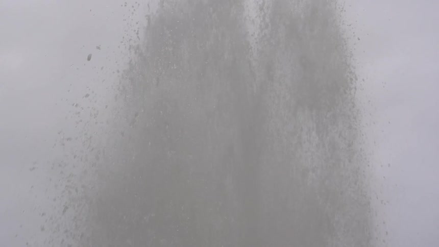 Water rushing up into the sky on a cloudy day