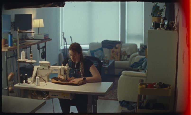 Woman sitting at home sews with a sewing machine during the day