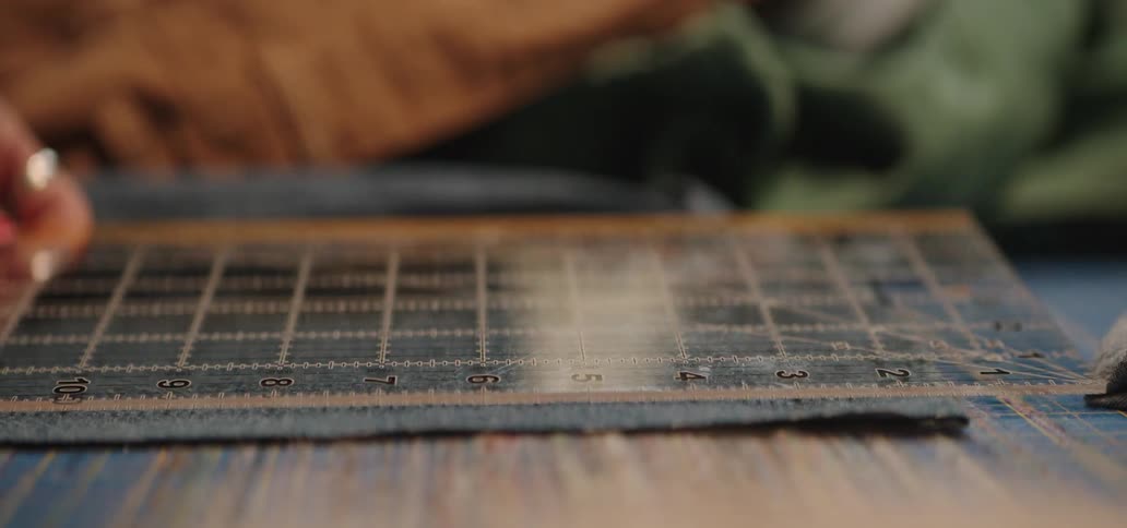 A person cutting fabric to sew