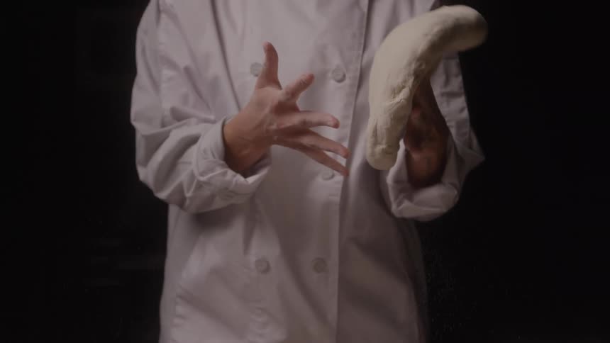 Baker prepares bread dough with hands in motion