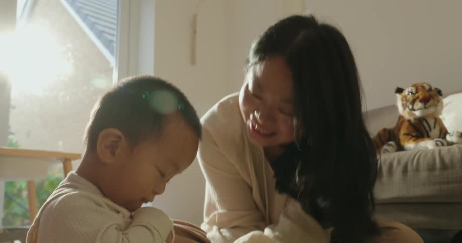 A mother tickling her young child