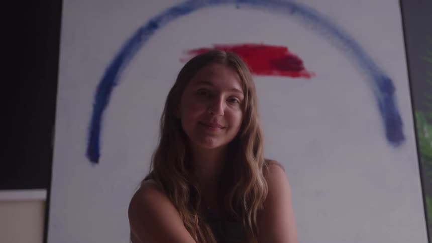 Portrait of a young woman sitting in an art studio
