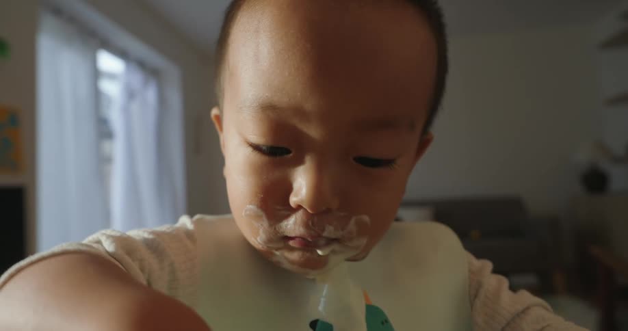 Child with messy hands covered in food during a meal