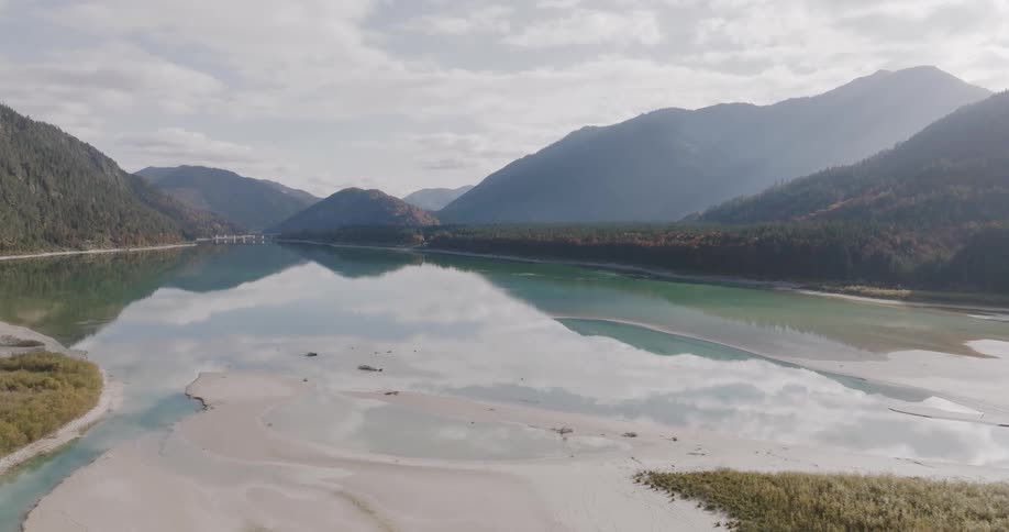Calm mountain valley lake with reflections and soft light
