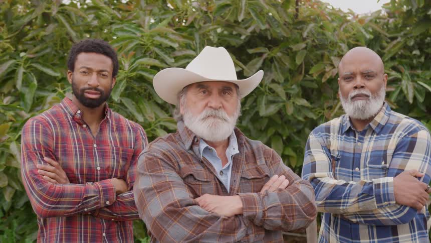 Three men stand and poses with their arms folded across their chests