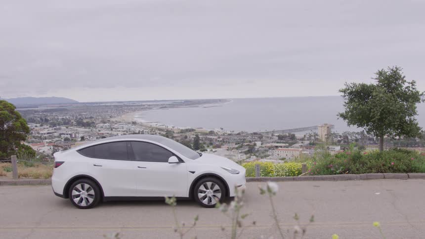 The white car drives on the road over the city
