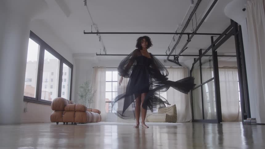 A woman is twirling in her dress in a big room