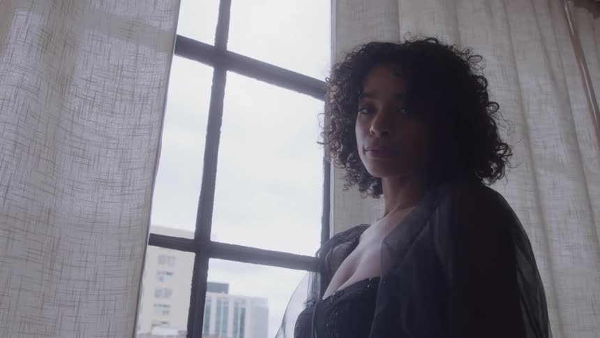 The woman looks out the window on a cloudy day
