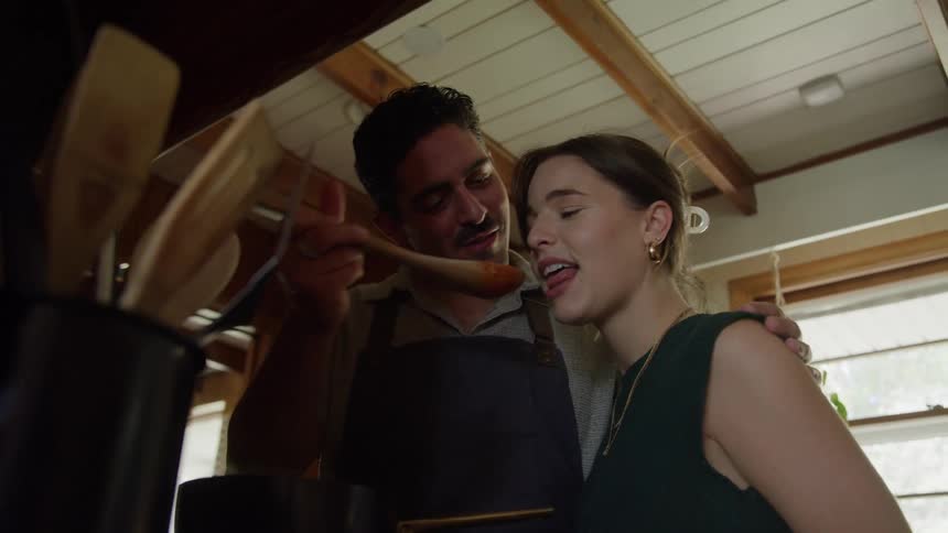 A persons hands are carefully mixing ingredients in a large white glass bowl on a wooden countertop the mixture appears to be a dough which the person is kneading together with their fingers