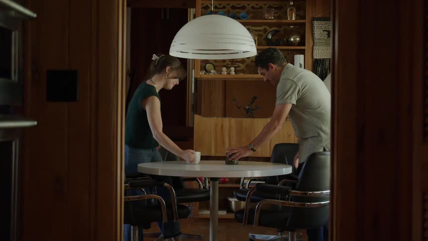 A smiling couple sits at a table enjoying coffee in a cozy wooden room