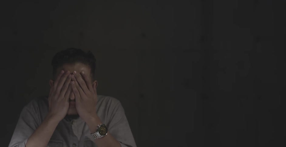 A man takes off his glasses and rubs his eyes