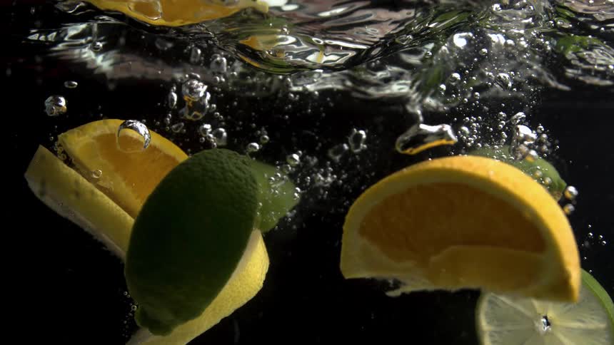 Citrus fruit is dropped into clear water