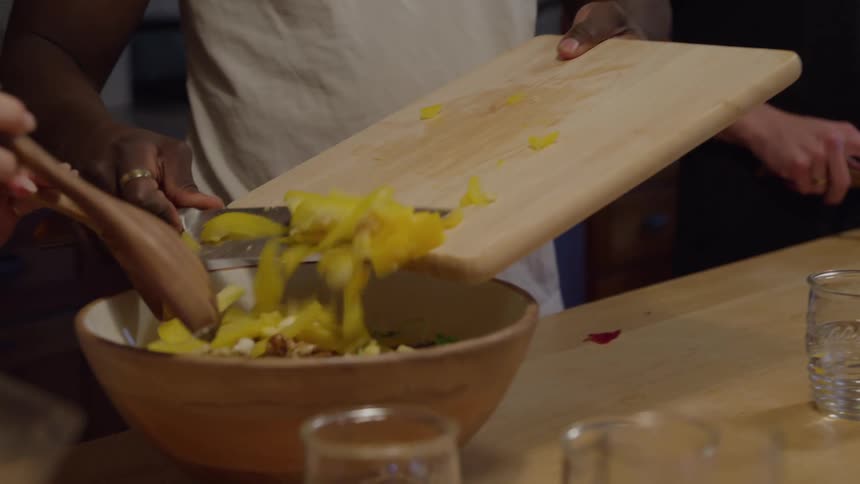 A group of people cutting vegetables to cook