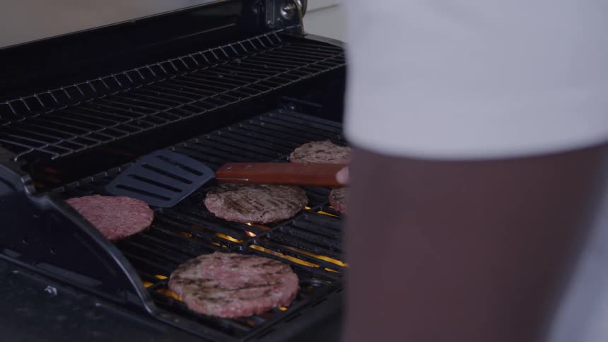 Burgers being grilled on a gas barbecue