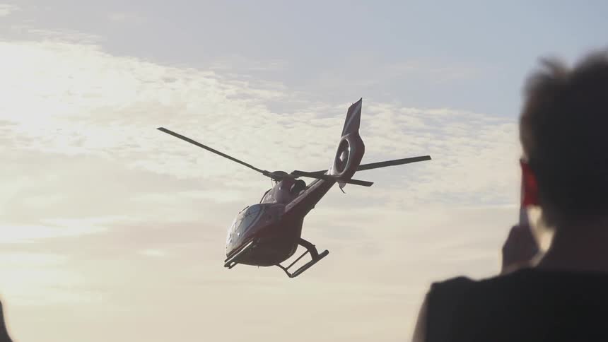 Person watches as a helicopter flies away