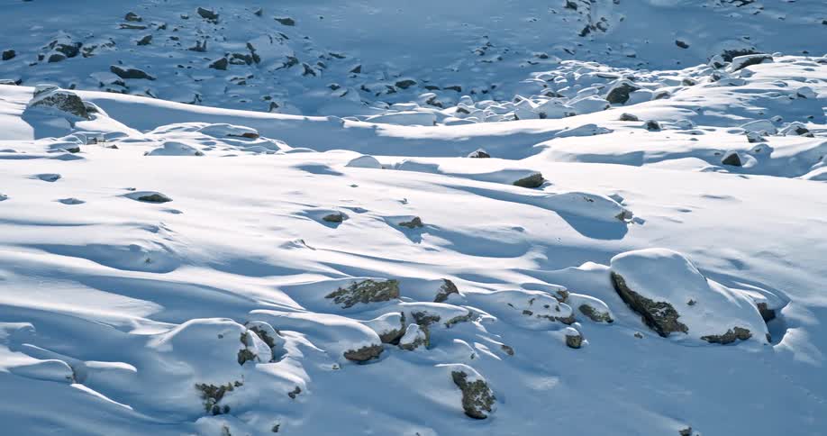 aerial of rocks and rough terrain on a snow covered mountain