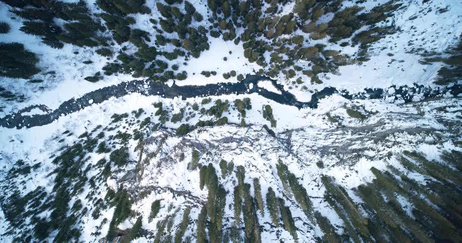 Top Shot of a river winding through the narrow valley between conifer forest