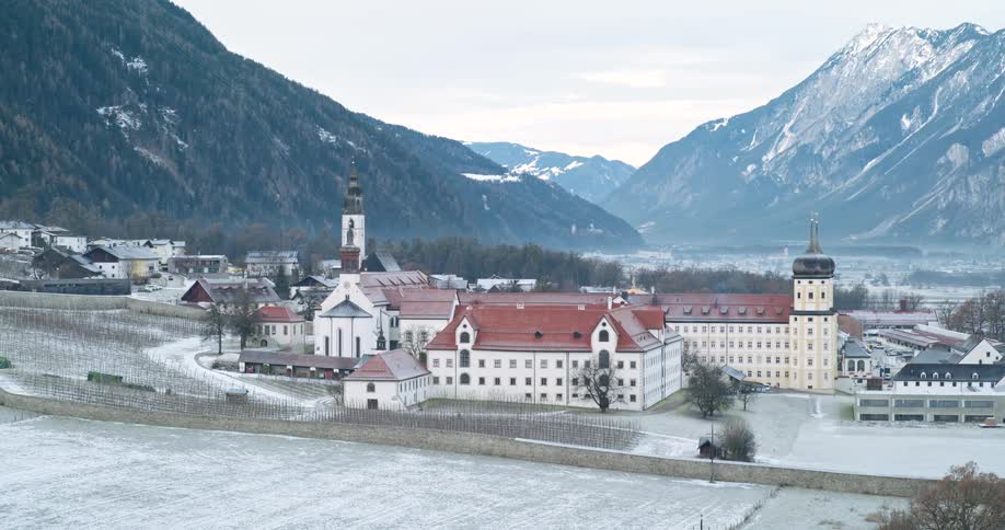 A large monastery building in the middle of a town in the snowy mountains