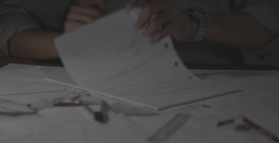 A man is writing on a desk