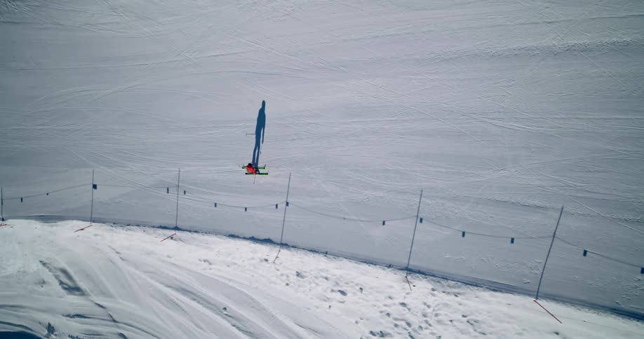 top shot of a Lone skier glides with a long shadow on a ski slope
