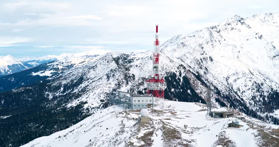 Buildings and cell phone tower on a snow covered mountain