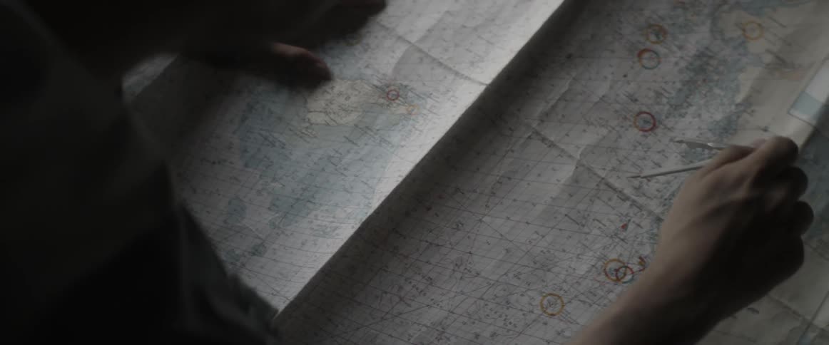 A person uses a compass to measure distance on a map