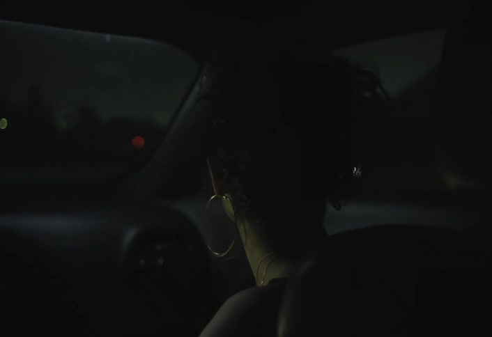 Woman looks out the car window at night