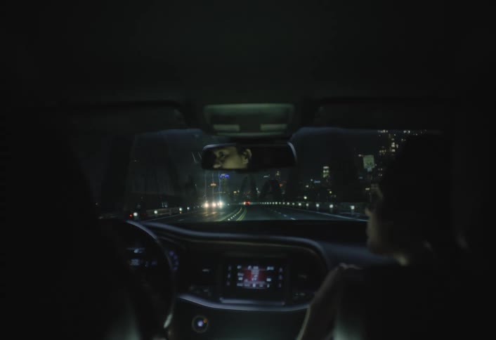 Two women are in a car driving down a highway