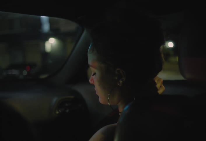 The woman riding in the car rubs her neck