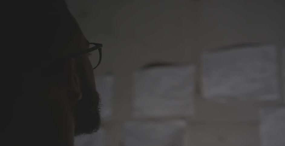Man looks at papers taped to a wall