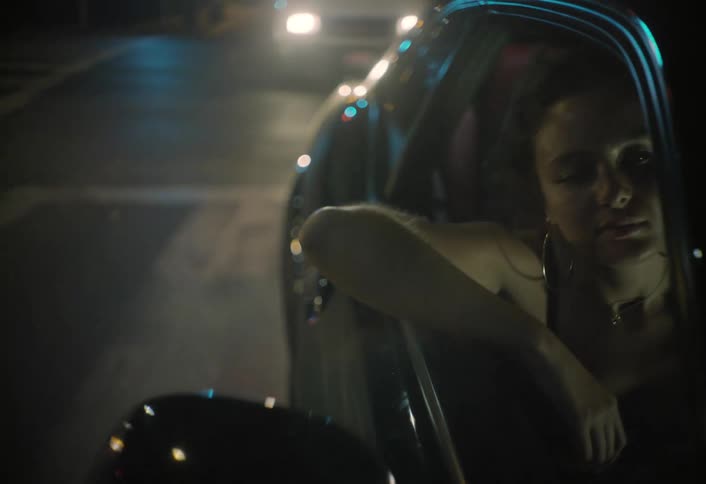 A woman riding in a car at night