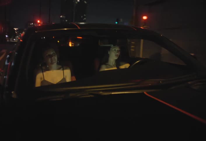 A woman driving in a car with a passenger