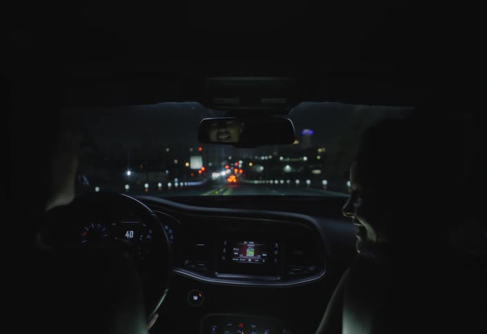 View from inside a car with two women traveling on a freeway at night