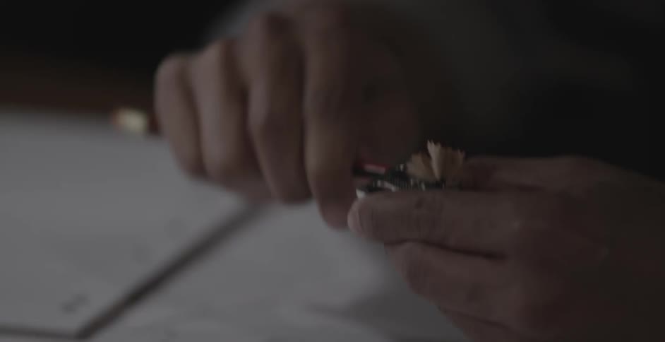 A person sharpens their pencil