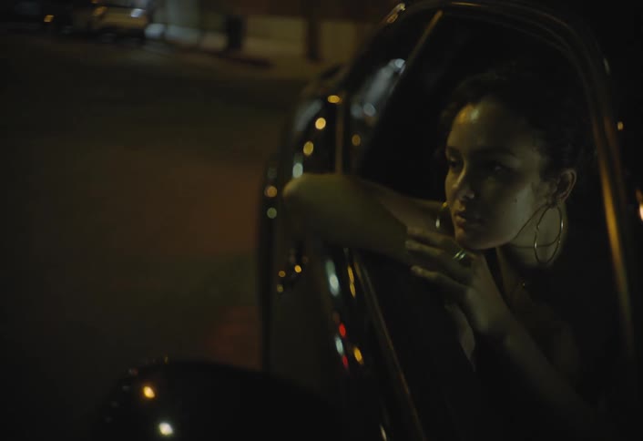 Woman rests her arms on the car window looking pensively outside