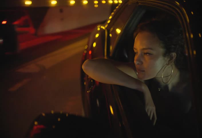 Young woman leans out of the car window moving in traffic