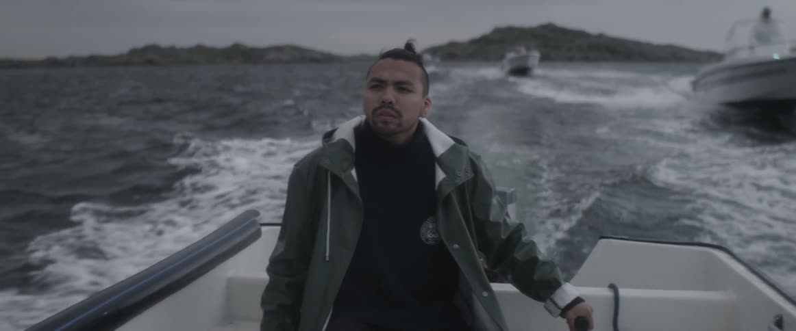 A man rides on a boat as others pass by