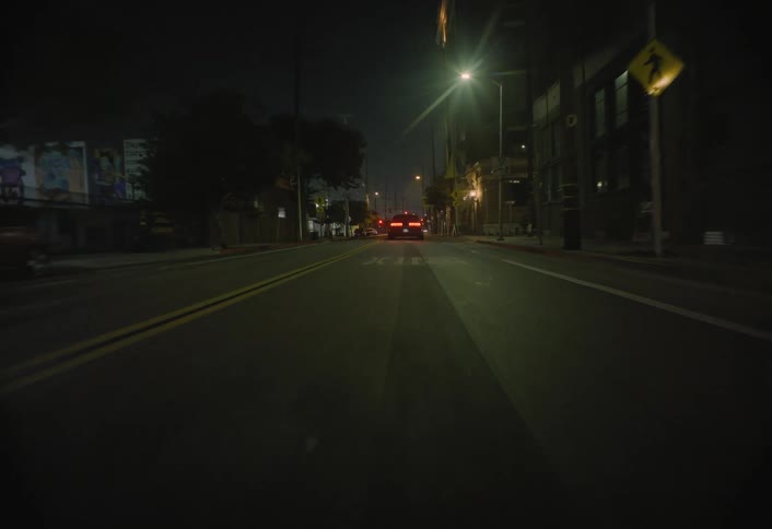 The car drives down the road at night