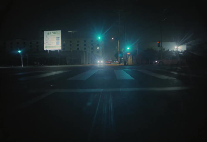 Traffic is moving down a street at night