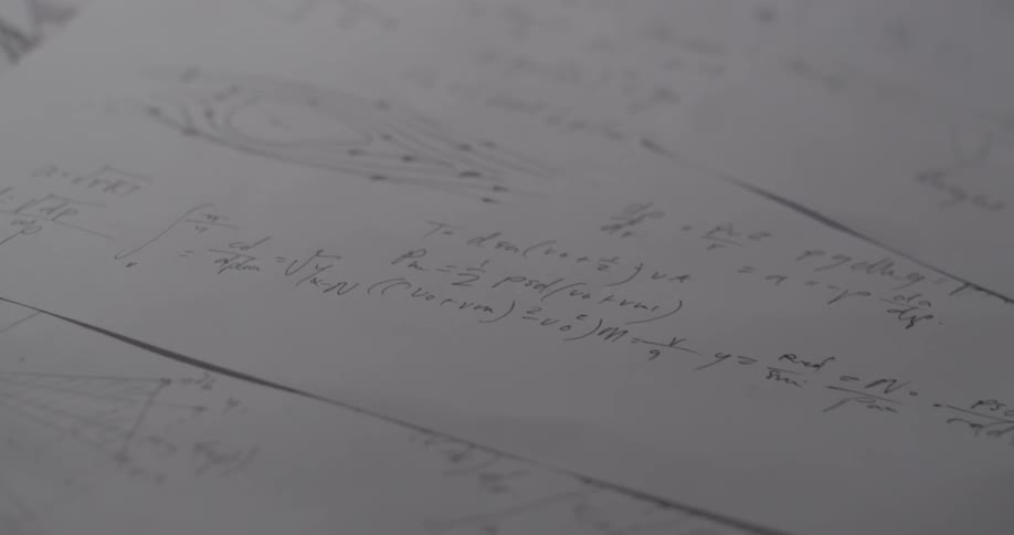 Equations are written on a piece of paper