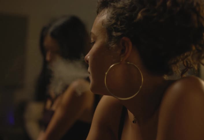 Woman smoking indoors under soft lighting