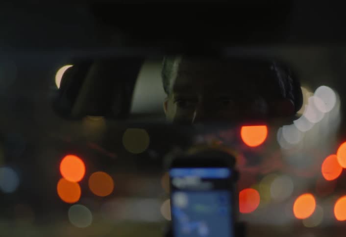 Drivers reflection in the rearview mirror at night