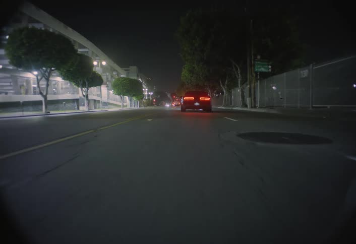 The car drives and slows down on the road at night