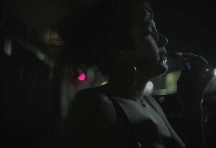 A woman walking down a street at night