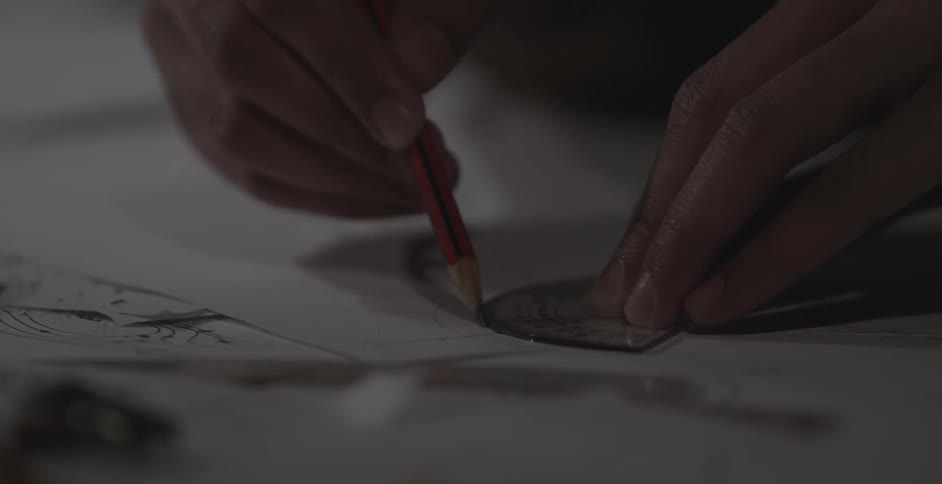 A man traces a curved ruler