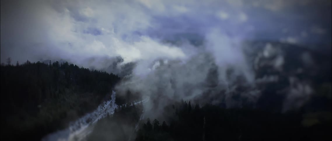 Mountain range full of trees and vegetation surrounded by clouds outdoors