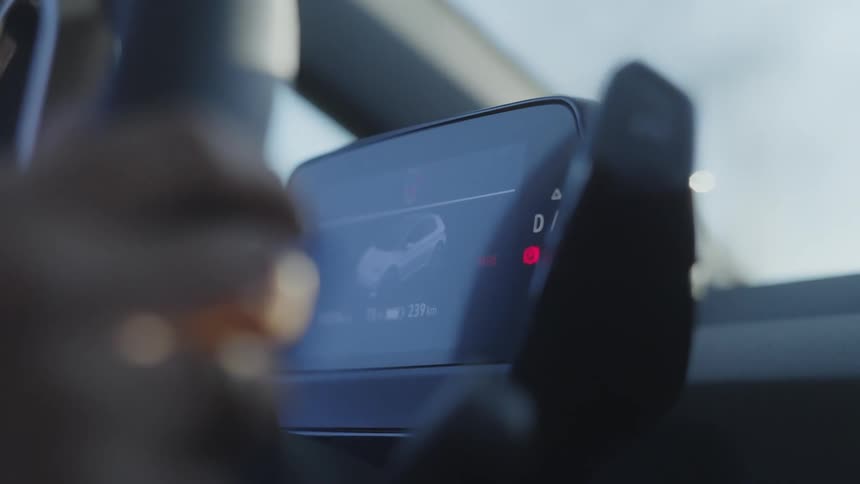 Close up of young woman operating an infotainment system while driving a vehicle during daytime