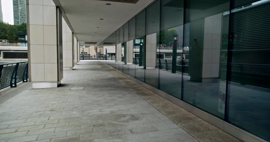 An exterior patio of a office building with a glass wall on the right side
